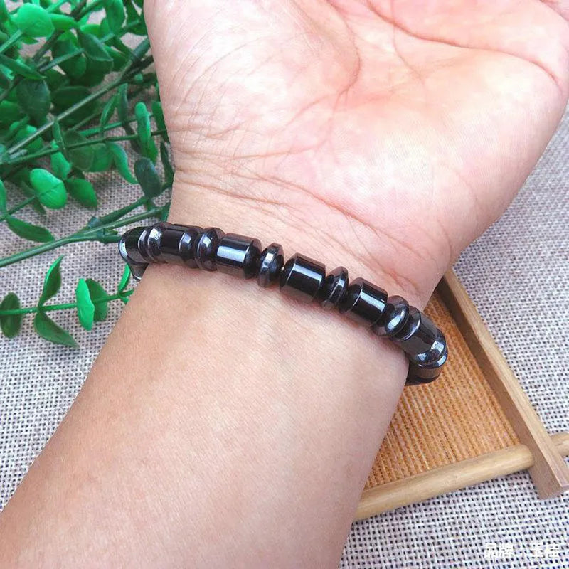 Black pentagram pattern magnetic therapy bracelet with magnetite and hematite stones on a stretch band.