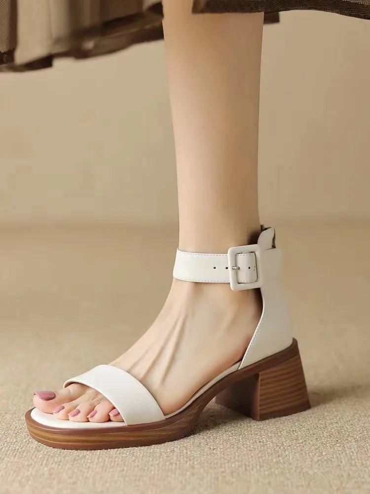 Women's white retro ankle-strap platform high heels with a round toe on a neutral background.
