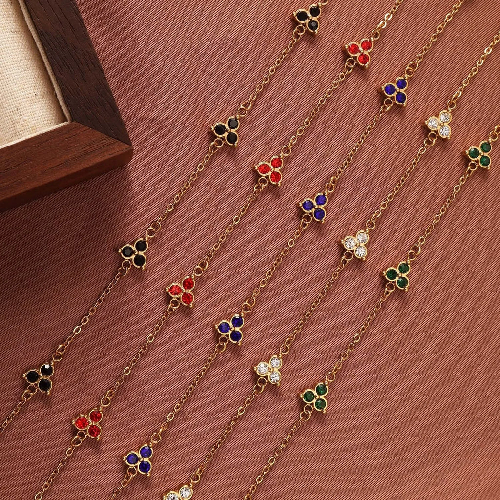 Women's stainless steel geometric bracelet with triangle design and three-diamond centrepiece in gold or steel finish.