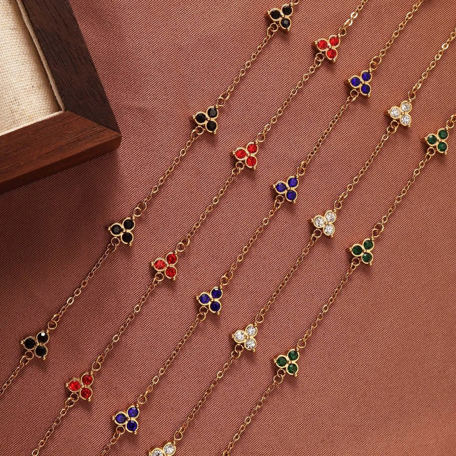 Women's stainless steel geometric bracelet with triangle design and three-diamond centrepiece in gold or steel finish.