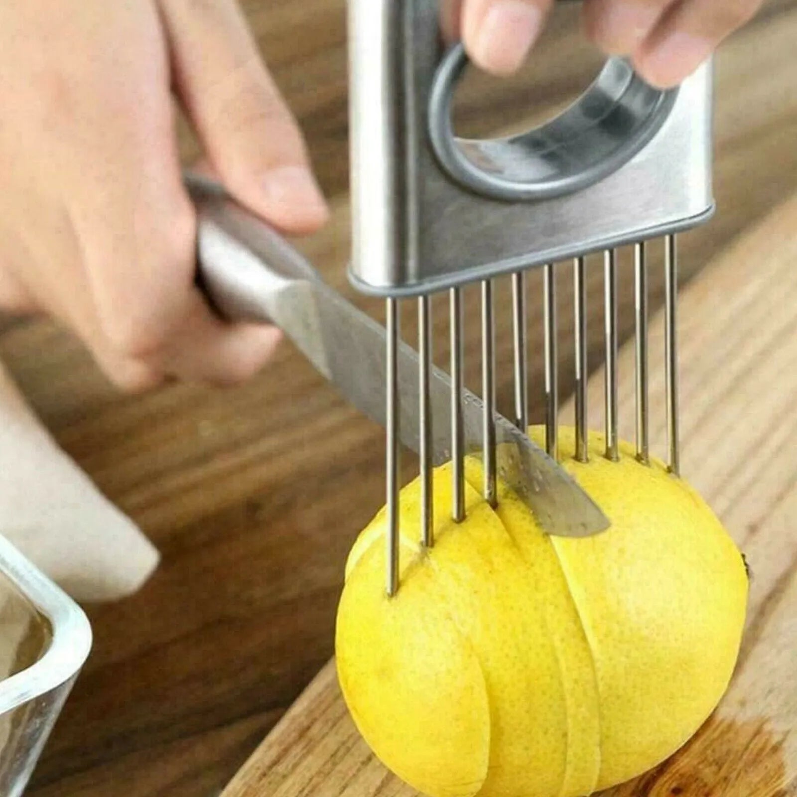 Stainless steel onion holder with ultra-sharp prongs and finger guard protector on a kitchen counter