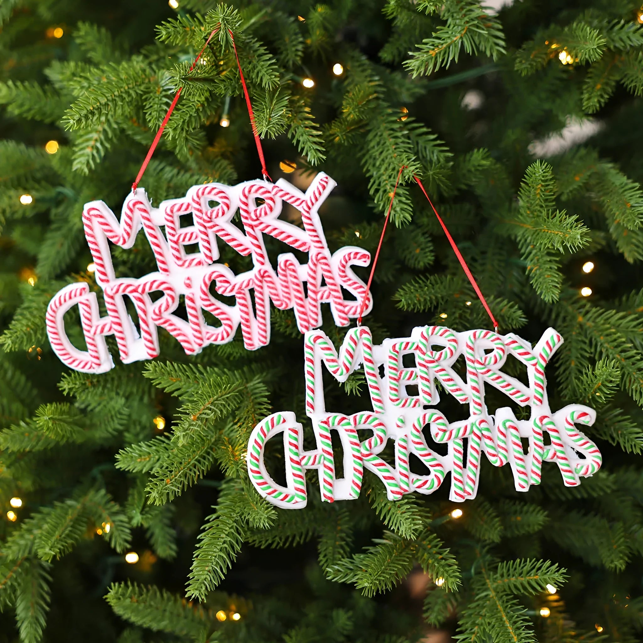 Merry Christmas letter plate polymer clay tree ornament in red, white and green plastic hanging on a tree branch