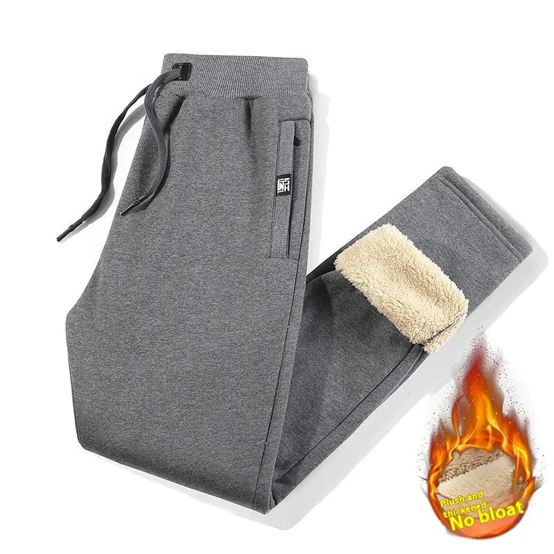 Men's grey fleece-lined cotton oversized track pants on a hanger, showing mid waist and straight leg.