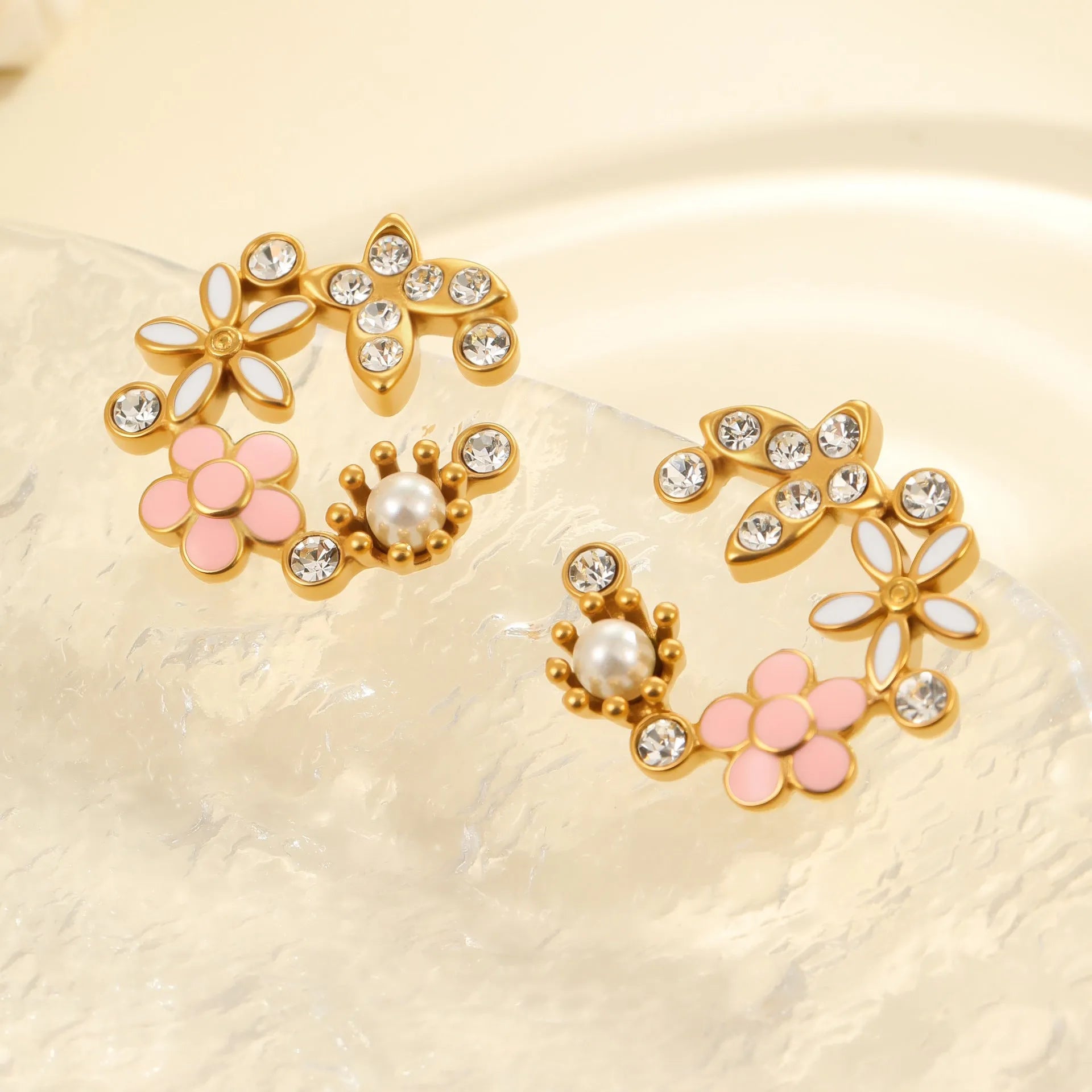 Close-up of colourful oil finish flower-shaped stud earrings with petal details on a stainless steel post.