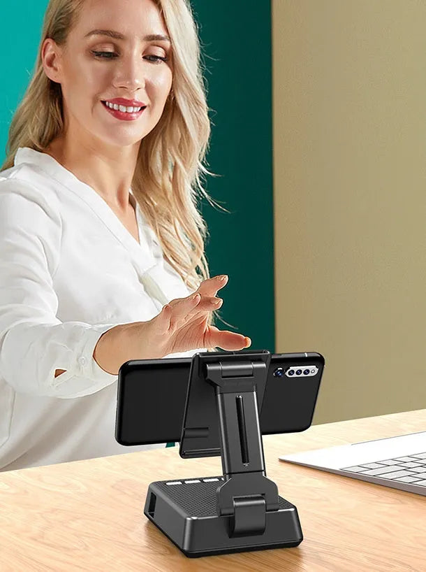 Black mobile phone broadcasting stand with integrated Bluetooth speaker and microphone on desk