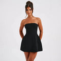 A woman wearing a solid colour backless A-line tube dress with a high waist and short skirt.