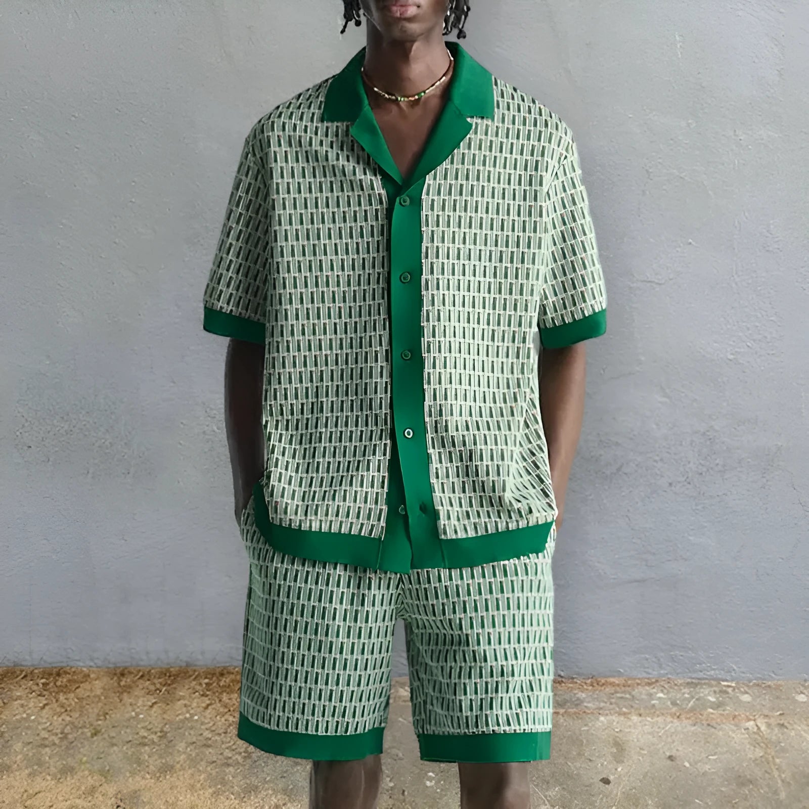 Man wearing a short-sleeved printed shirt and matching shorts from a men's two-piece beach set.