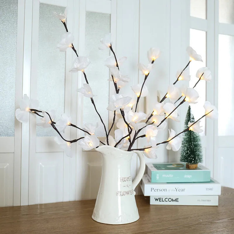 Pink LED Phalaenopsis branch decorative light on a table, 65cm long with fabric cover.