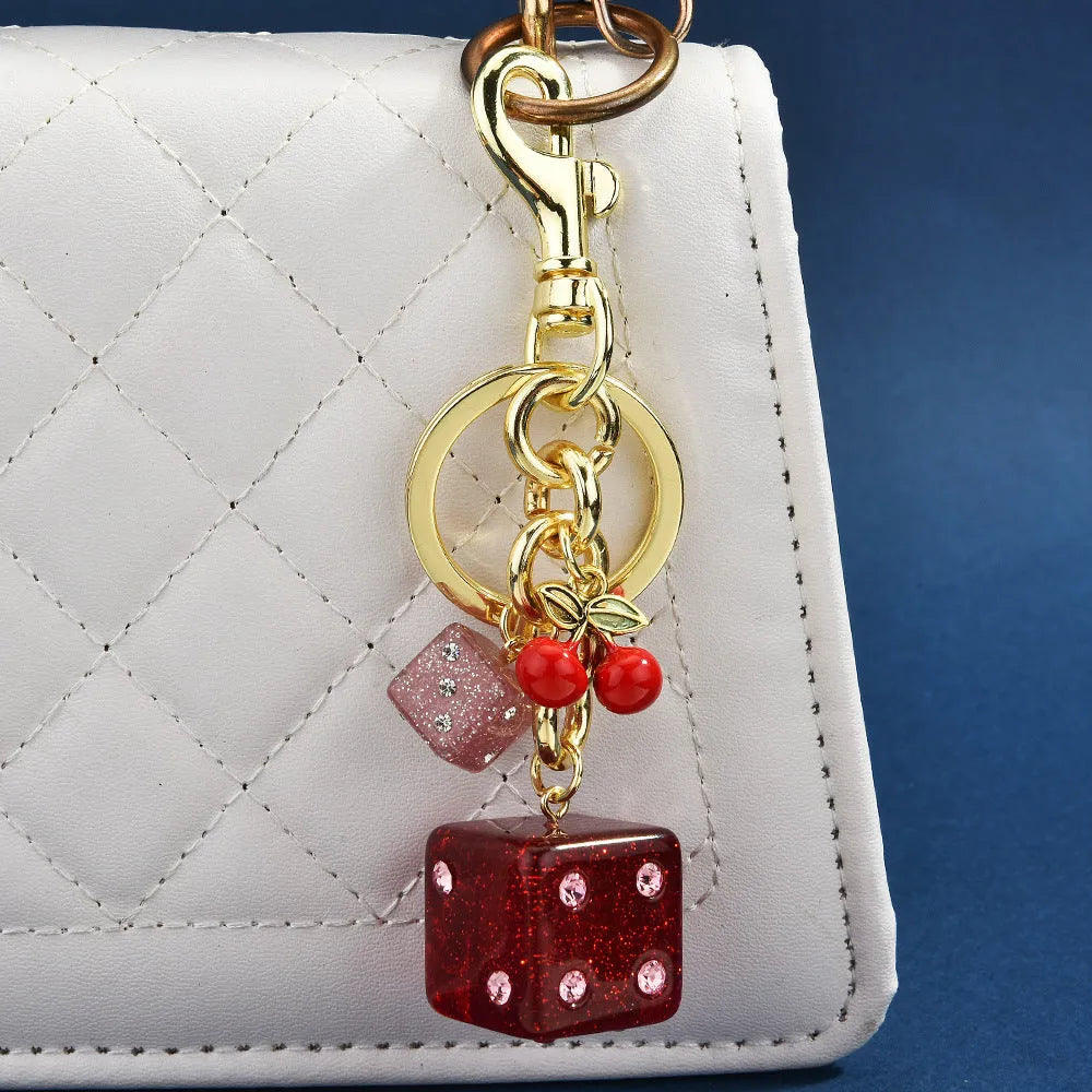 Square metal keychain pendant with cherry two-tone dice design and electroplated finish