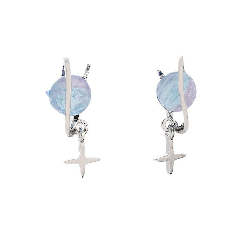 Metal geometric planet earrings in multicolour finish on a neutral background