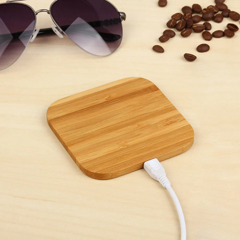 Square wooden bamboo 5W Qi wireless charging pad for smartphones on a table.