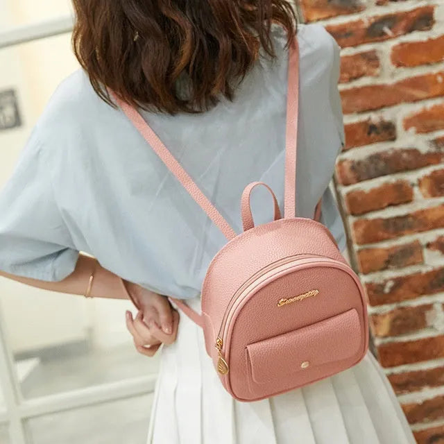 Women's compact black PU bag worn as both a shoulder bag and a small backpack.