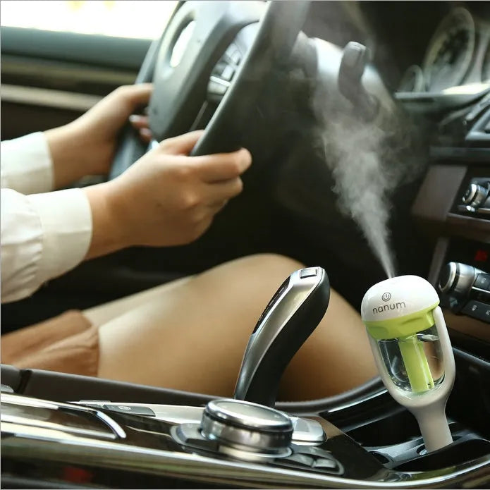Compact blue car humidifier with rotating nozzle on car dashboard