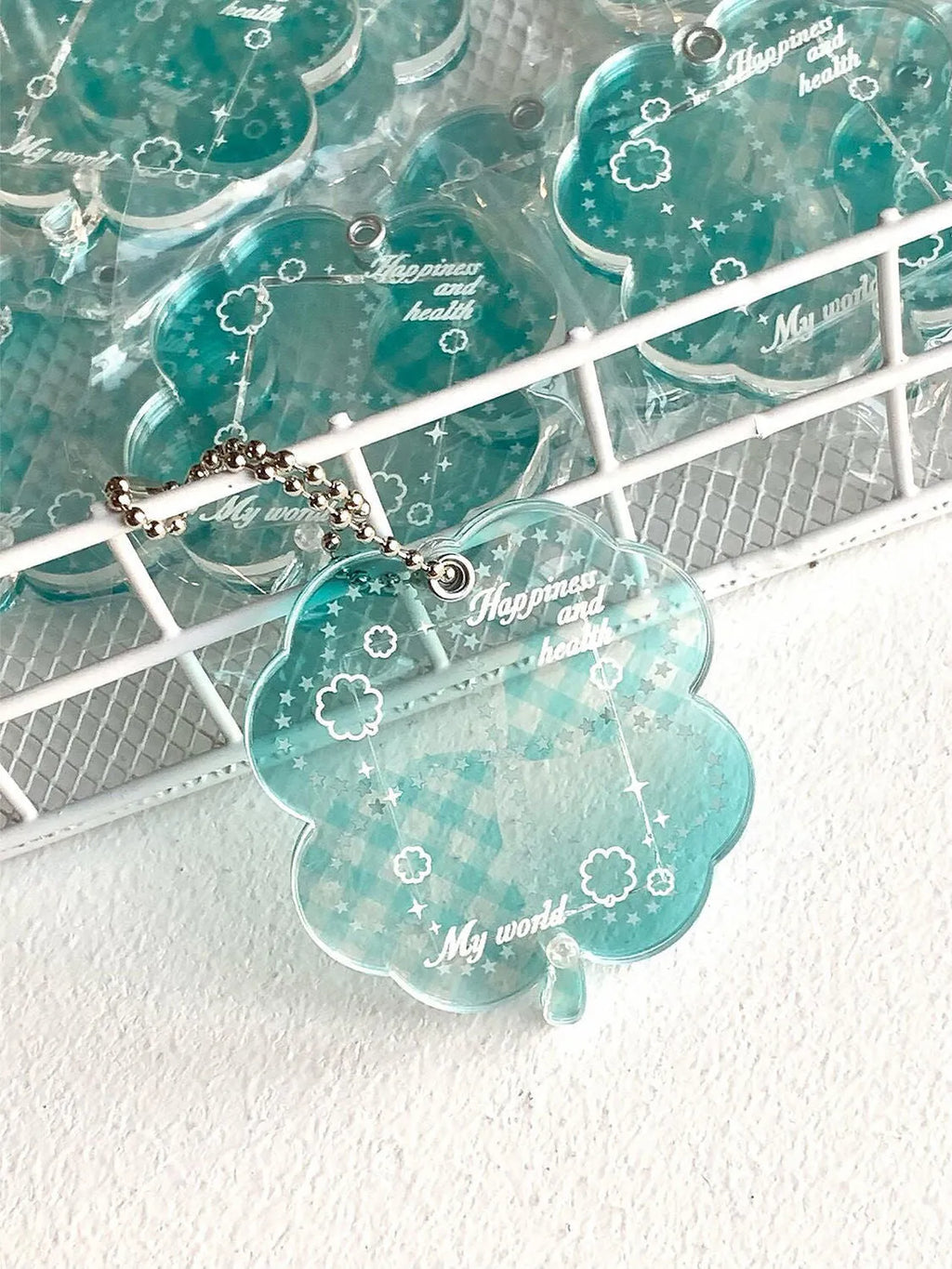 Acrylic four-leaf clover keychain pendant in blue, green, or mint colour options.