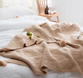 Nordic-style fringed knit acrylic blanket in a neutral colour, laid flat showing its 130x170cm size.