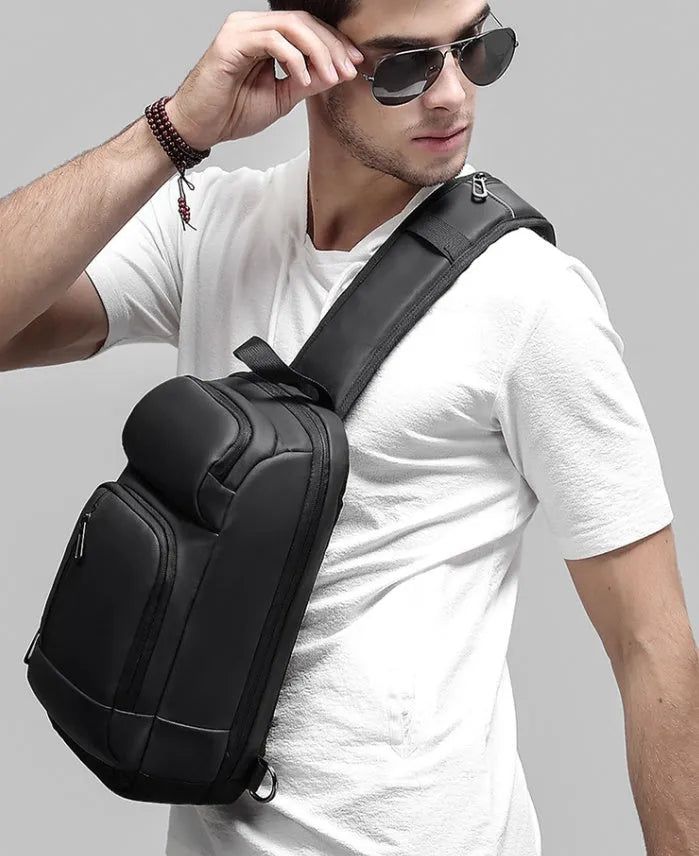 Black medium-sized PVC outdoor shoulder bag with a single strap and internal organiser pockets.