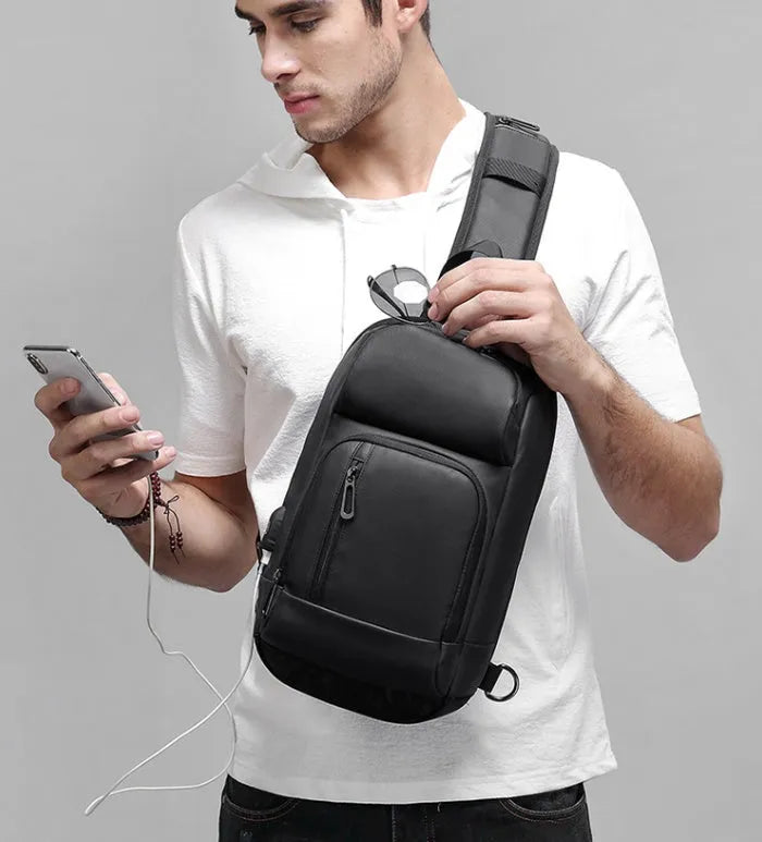 Black medium-sized PVC outdoor shoulder bag with a single strap and internal organiser pockets.