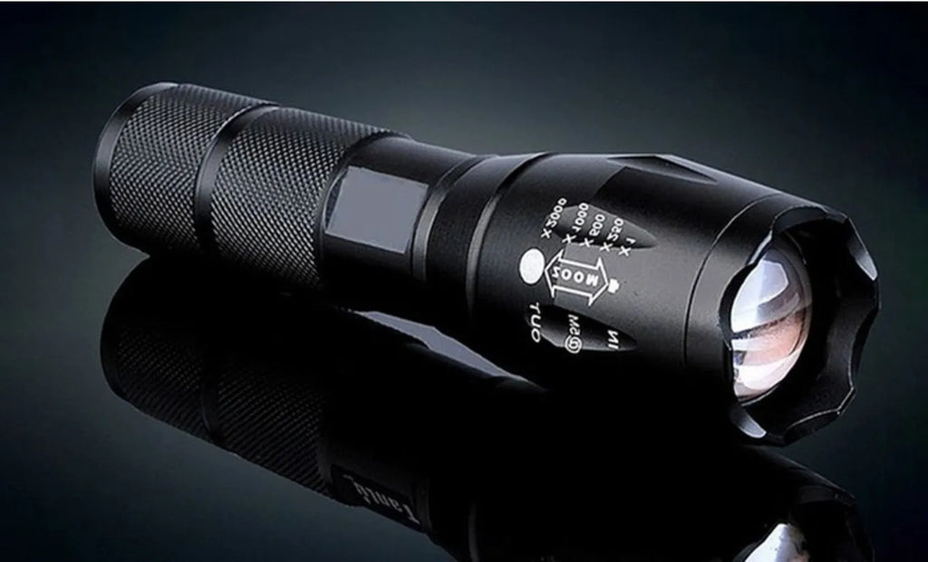 Black aluminium alloy zoomable LED flashlight with adjustable focus ring on a textured body.