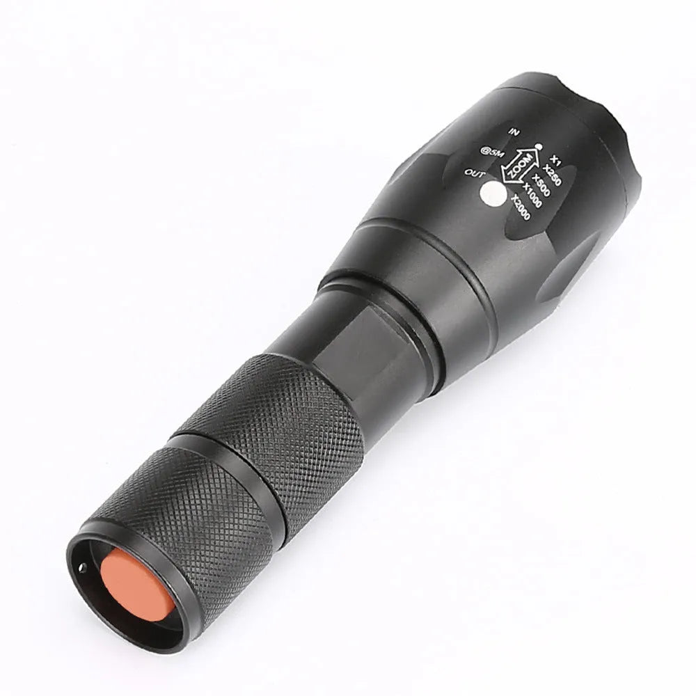Black aluminium alloy zoomable LED flashlight with adjustable focus ring on a textured body.