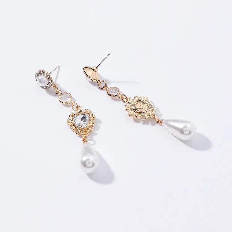 Gold pearl drop earrings with heart-shaped alloy frame and single pearl pendant on gold-tone finish