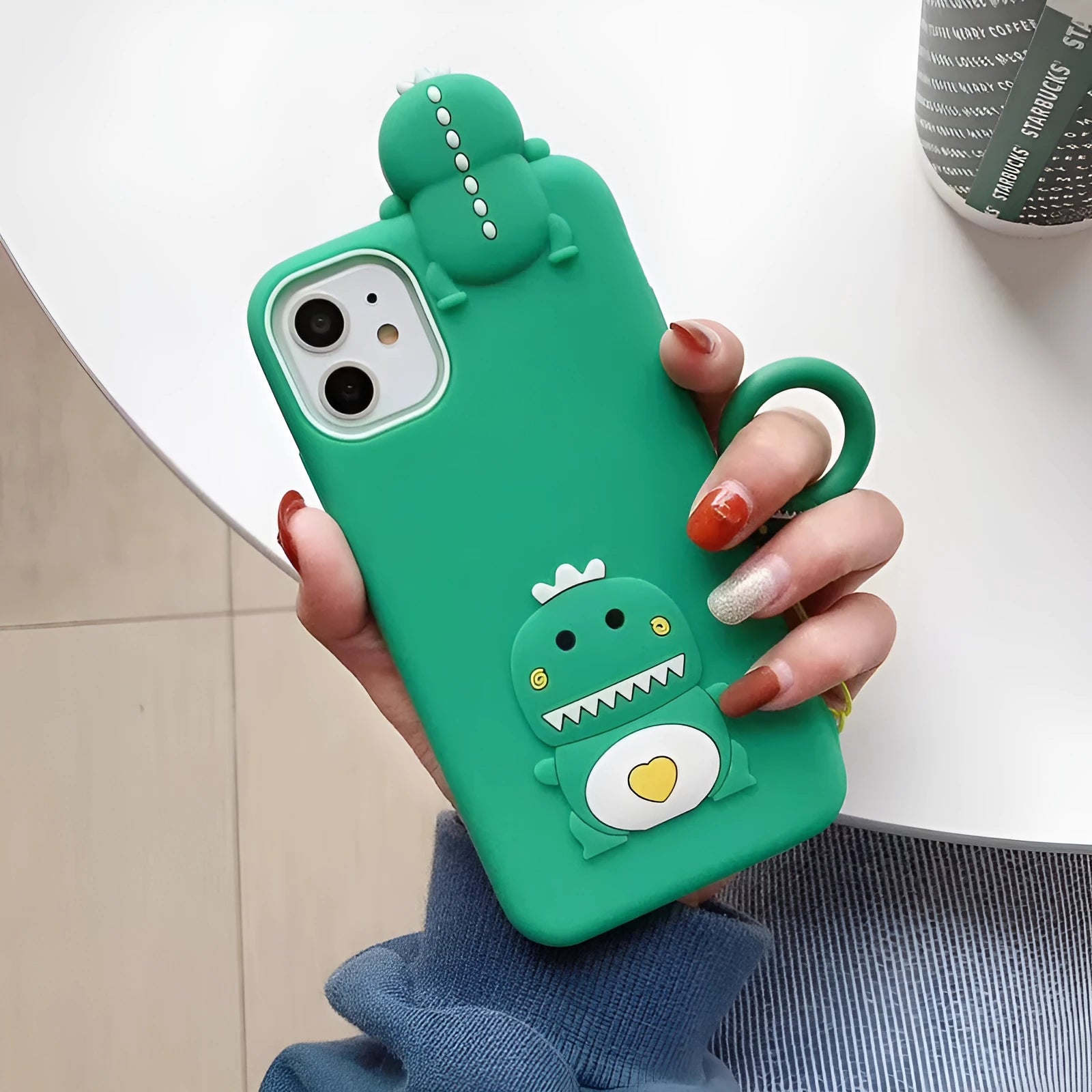 Green silicone iPhone case with cartoon animal design showing waterproof and drop protection features