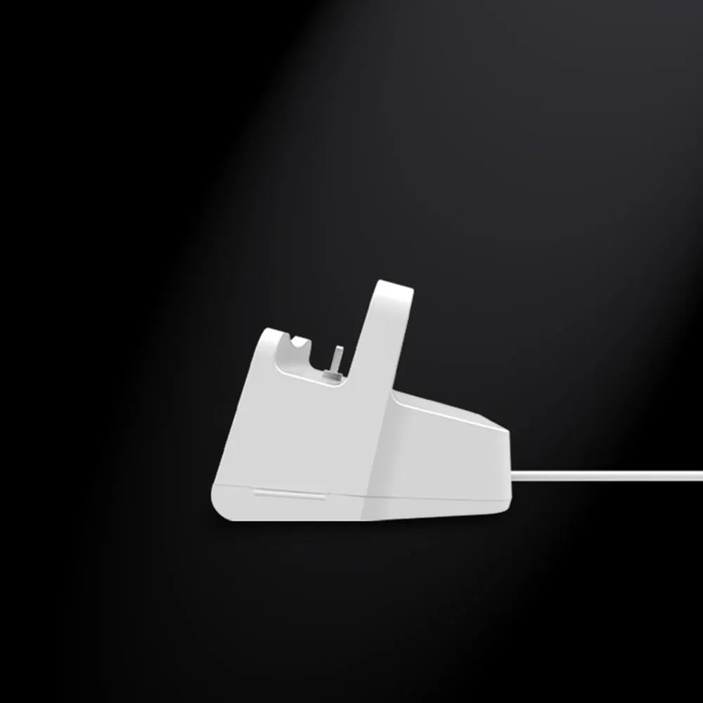 White headphone charging base stand on a desktop holding a gaming headset