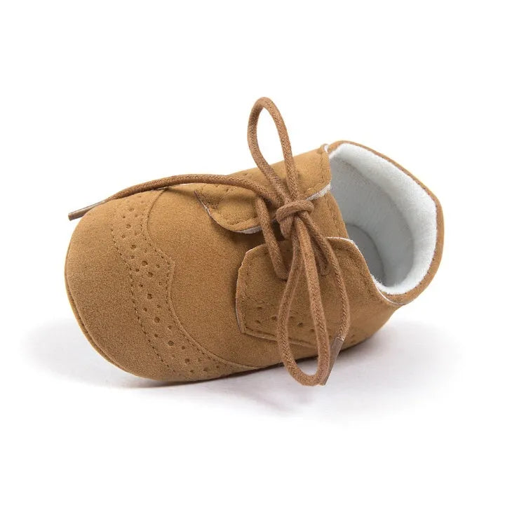 Vintage-style soft-soled baby shoes in synthetic leather with plain pattern design