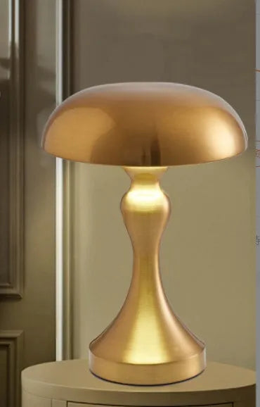 Metallic-finish USB charging desk lamp with touch control on a wooden desk.