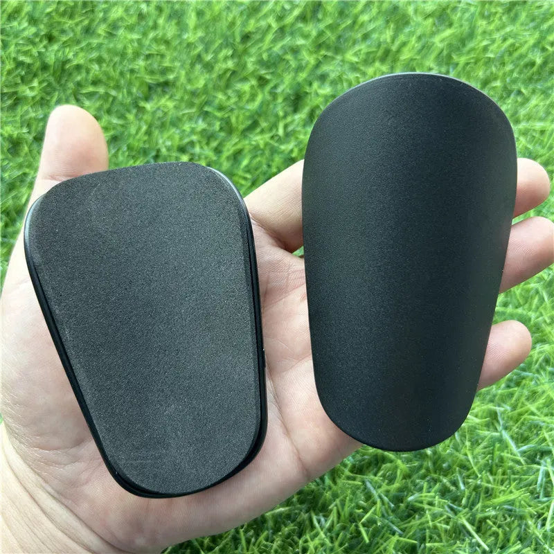 Extra small mini football shin guards measuring 8x5cm in black and white colours