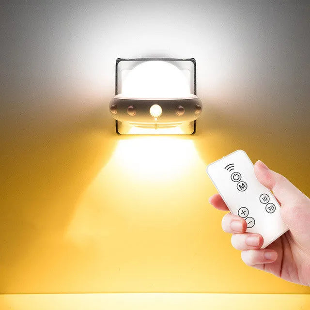Blue UFO-shaped bedside night light with remote control on a wooden table.