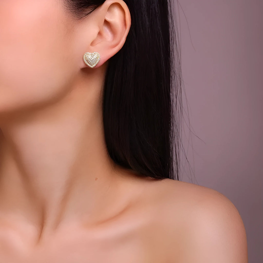 A pair of gold-coloured heart-shaped hoop stud earrings with moissanite stones on S925 sterling silver posts.
