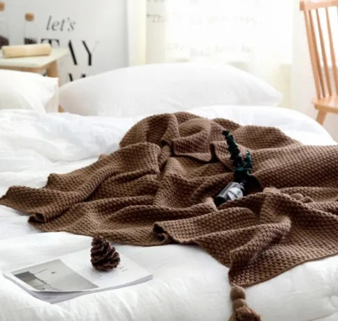 Nordic-style fringed knit acrylic blanket in a neutral colour, laid flat showing its 130x170cm size.