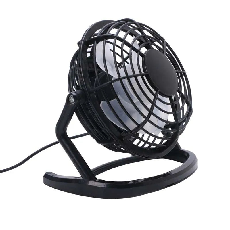 Mini black USB desk fan with adjustable head on a wooden desk next to a laptop.