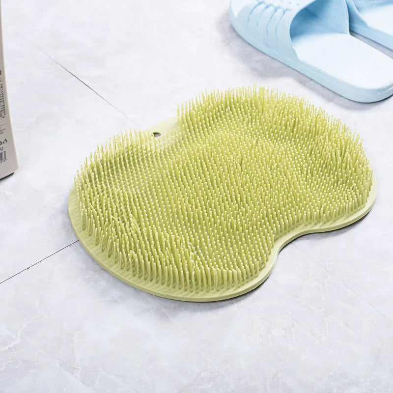 Orange TPR bath brush with silicone bristles and suction cups on base, shown on bathroom tiles.