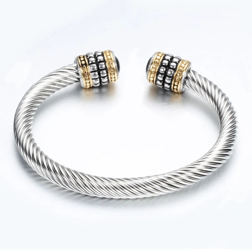 Two-tone vintage gold stainless steel bangle bracelet with black and golden finish on white background