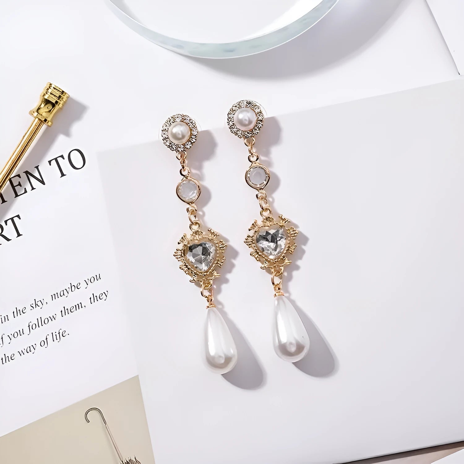 Gold pearl drop earrings with heart-shaped alloy frame and single pearl pendant on gold-tone finish