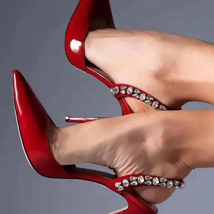 Women's patent leather high heel sandals with pointed toe, clear ankle strap, and rhinestone details.