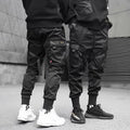Men's black cotton harem joggers with side pockets and elastic waist, shown with drawstring and Velcro closures