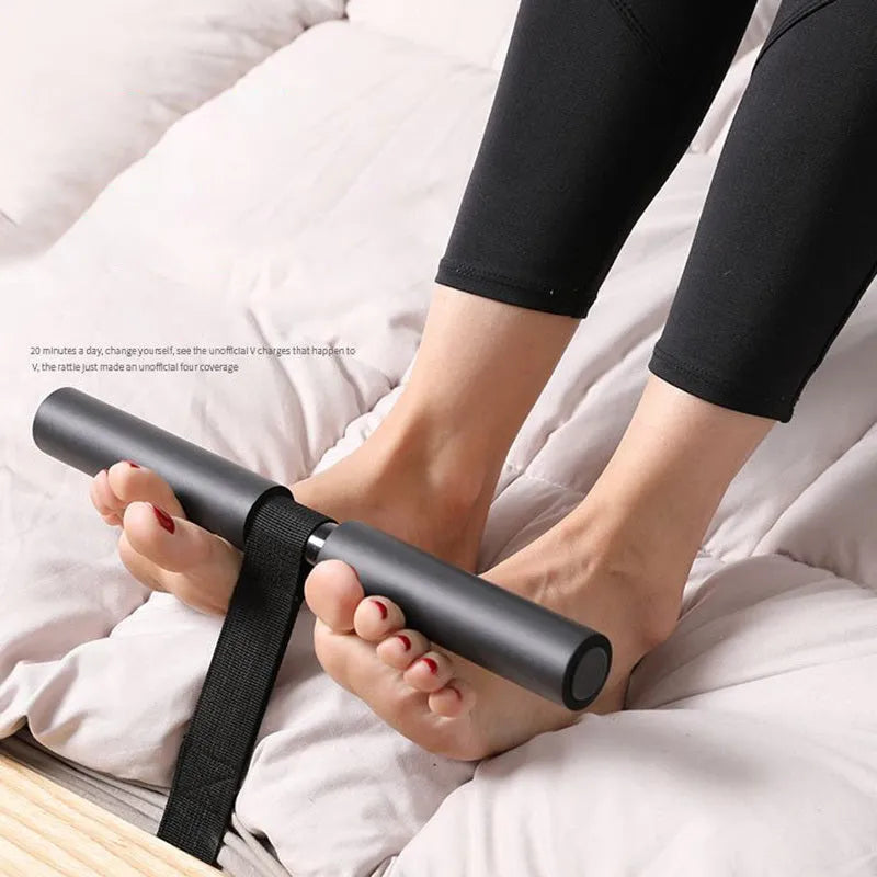 Black portable abdominal fitness device on a flat surface, showing steel frame with foam and PVC handles