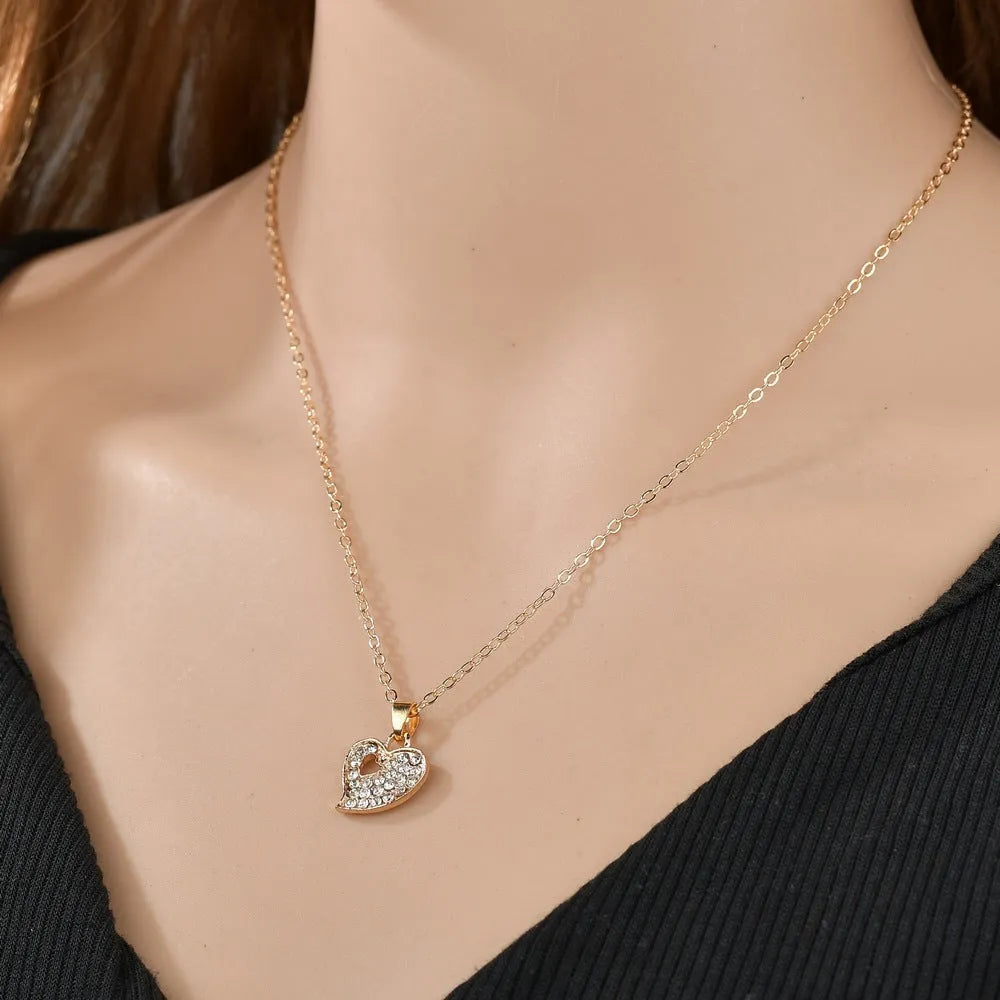 Gold electroplated women's jewellery set with love pendant necklace, earrings, and bracelet on a white background.
