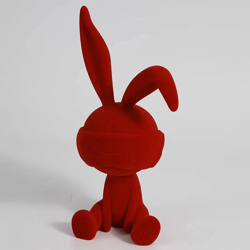 Green suede blindfold rabbit resin table ornament on wooden surface