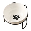 White ceramic cat bowl with cat paw print design on a black iron frame stand