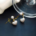 A pair of Korean-style heart-shaped stud earrings with inlaid artificial gems on an alloy base.