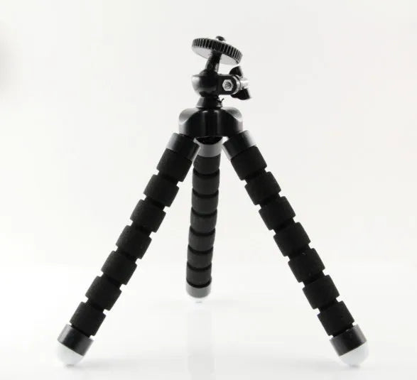 Black flexible octopus tripod with wrapped legs next to a smartphone, showing its 18cm size and universal screw mount.