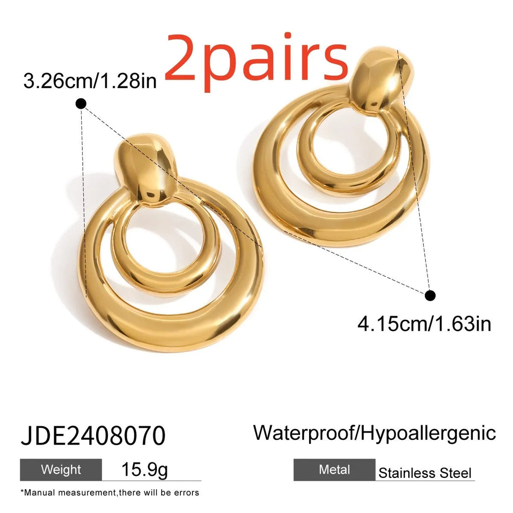 Close-up of a pair of round, geometric, double-layer hollow stud earrings with a golden electroplated finish.