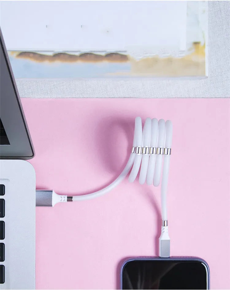 White magnetic nano data line with aluminium alloy joints and multiple connector heads on a desk