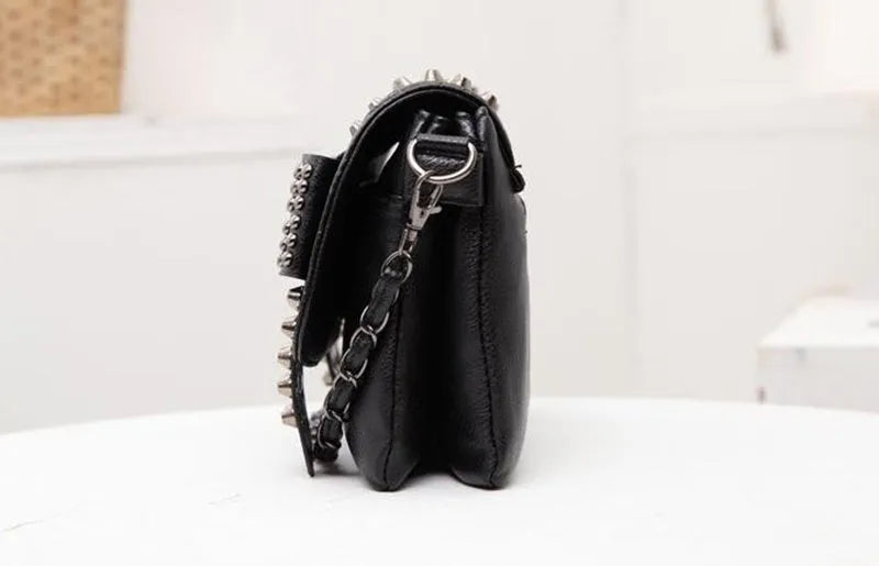 Black leather messenger bag with skull rivets and buckle closure for women