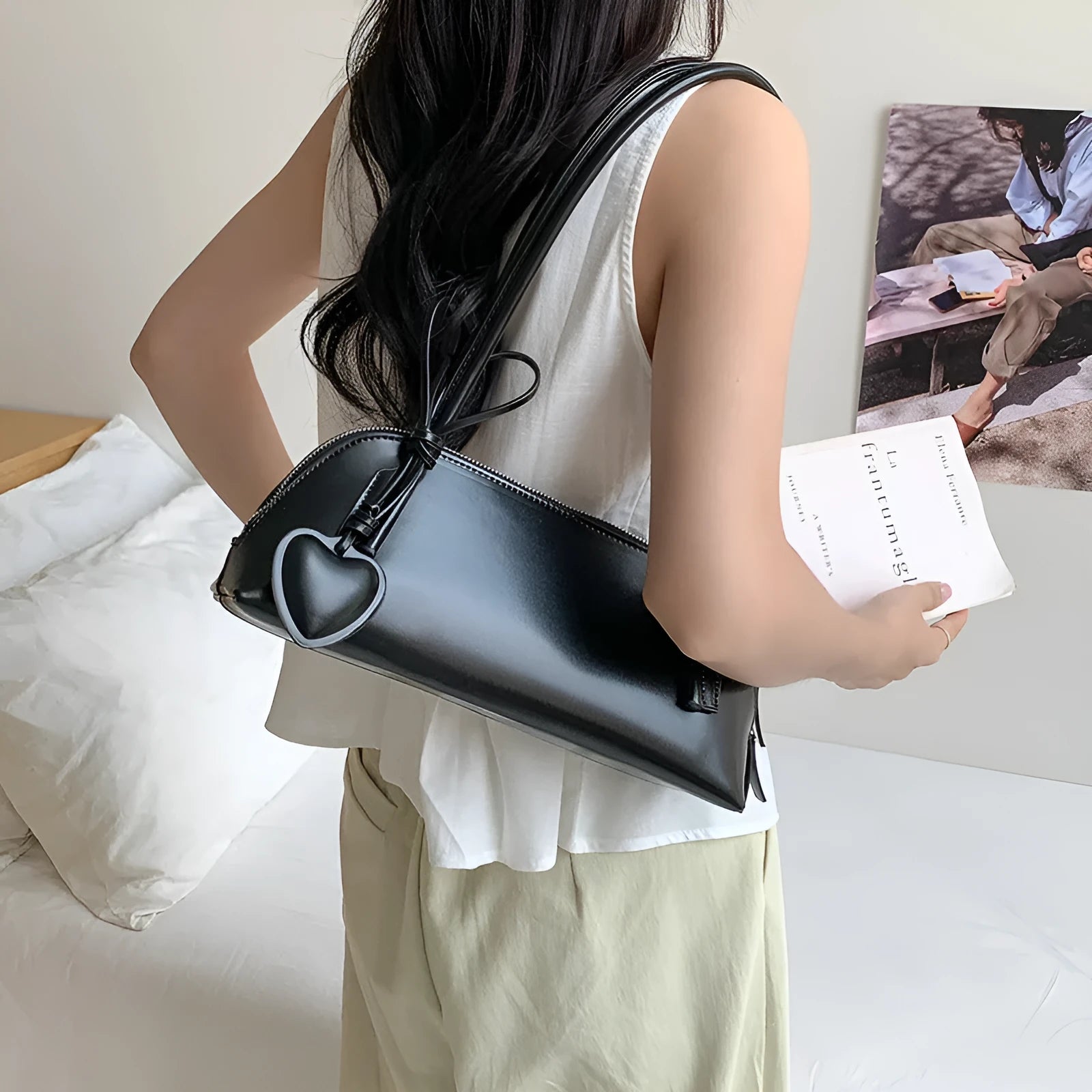 Crossbody shoulder bag in black PU with double straps, horizontal square shape, and visible sewing thread detail on front