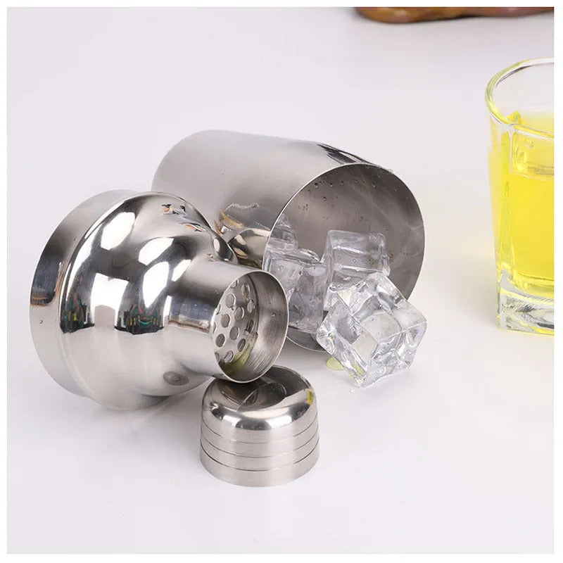 8pc stainless steel cocktail shaker set with graduated pieces on a table, various heights from 11cm to 18cm