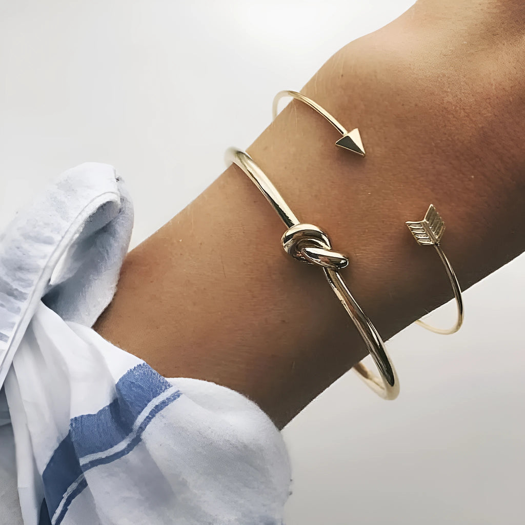 Gold women's vintage cuff bracelet with arrow knotted design on wrist